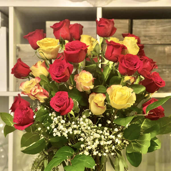 Bouquet of red and yellow roses in a glass vase