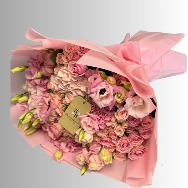 Pink bouquet of roses and lisianthus wrapped in pink paper
