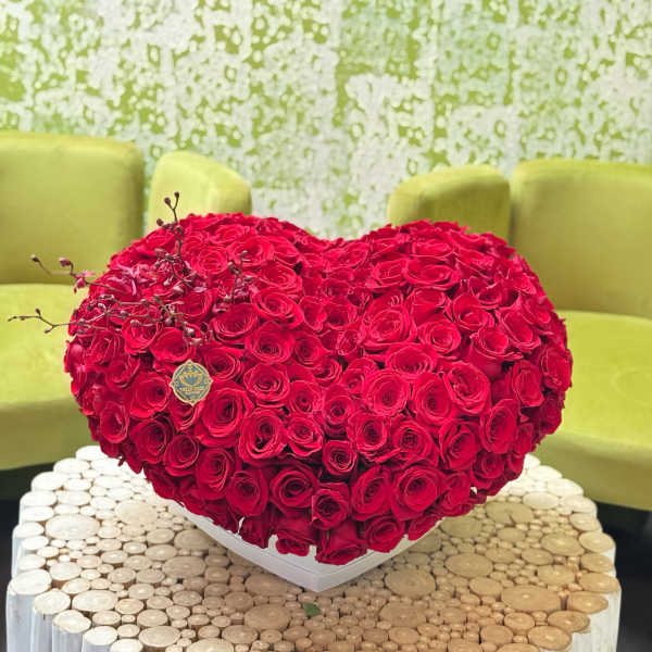 Heart-shaped arrangement of red roses in a white box