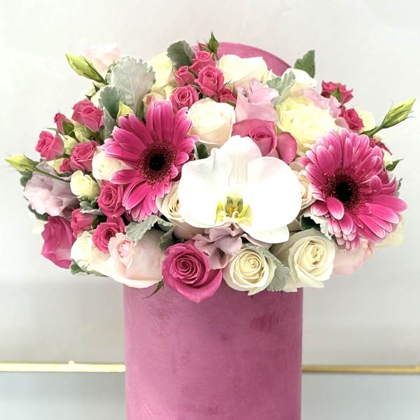 Pink and white bouquet with roses, gerbera daisies, and an orchid in a pink box