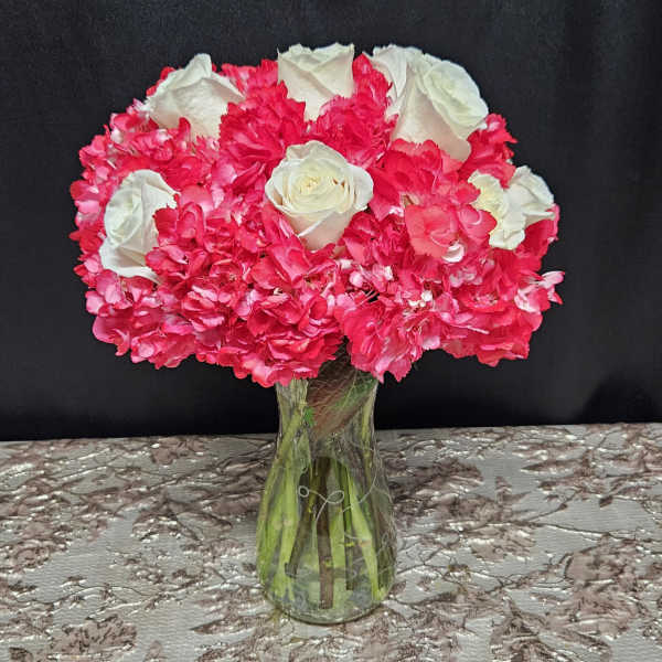 Pink and white rose bouquet in a clear glass vase