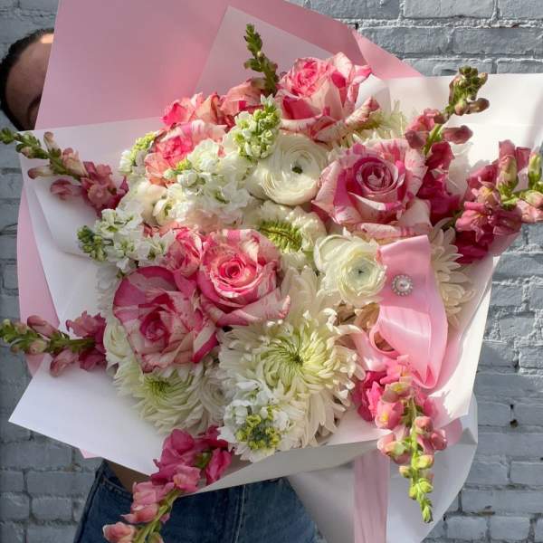 Bouquet of pink and white flowers wrapped in pink paper