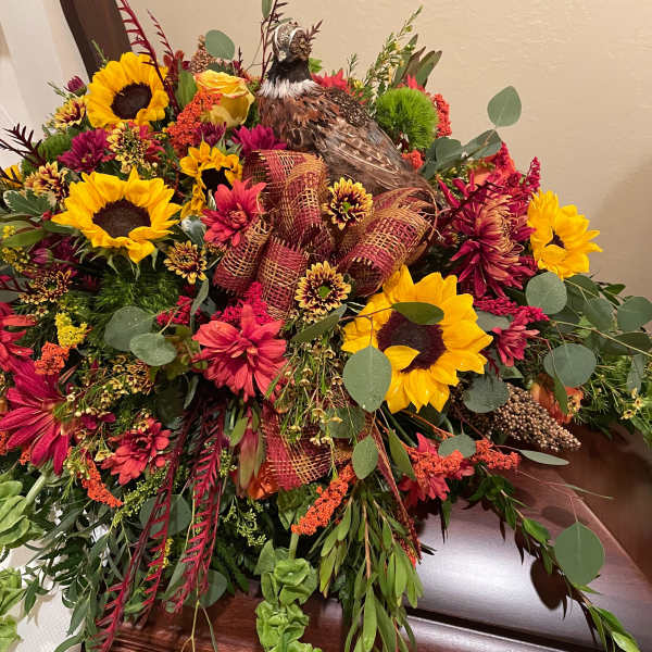 Large floral casket spray with sunflowers and a pheasant centerpiece