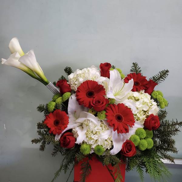 Red gerberas and roses with white lilies in a red container