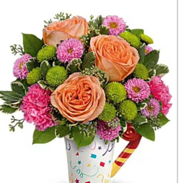 Bouquet of peach roses and pink flowers in a decorated cup