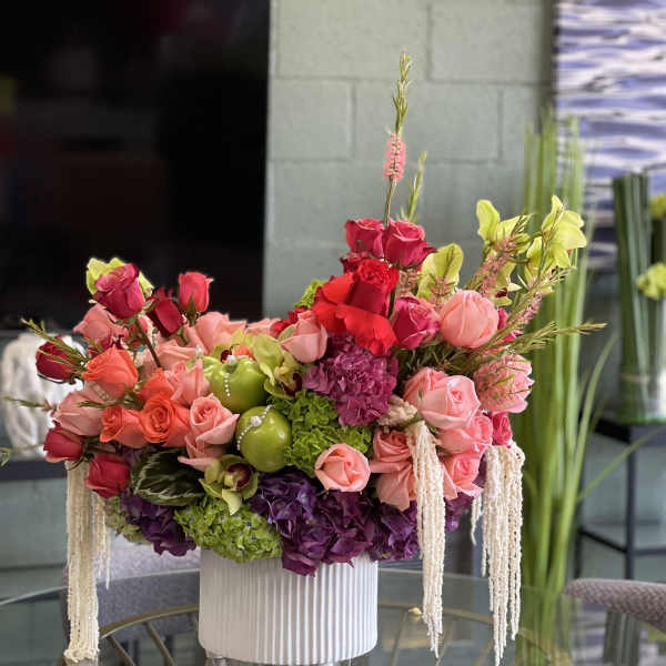 Large arrangement of pink and red roses in a white vase