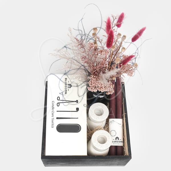 Gift box with dried flowers, candles, and a candle care tool kit