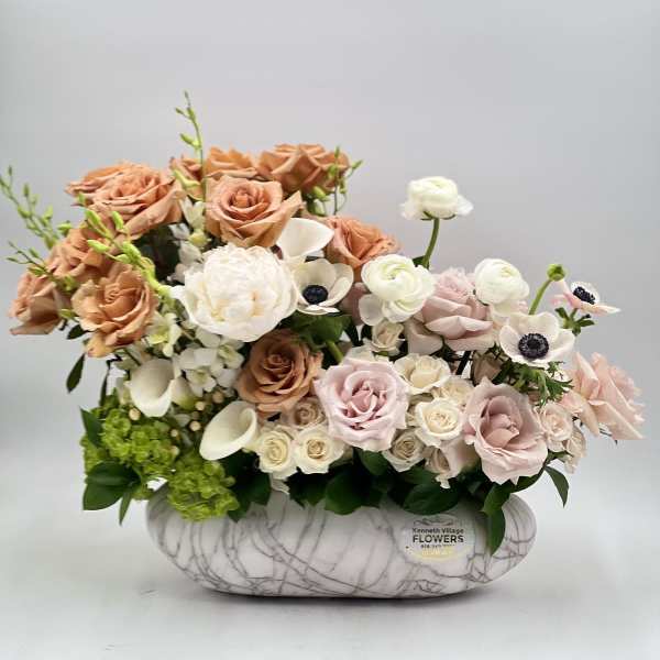 Arrangement of blush and white roses in a marble-patterned vase