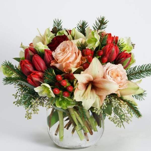 Bouquet of red and peach flowers in a clear glass vase