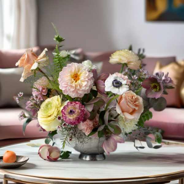 Pastel floral arrangement in a silver bowl on a table