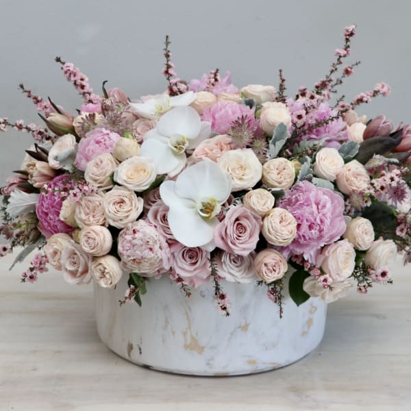 Pink and white floral arrangement in a round white vase