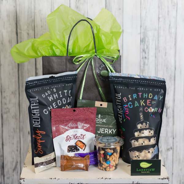 Gift bag filled with snack bags, candy, and a jar of mixed nuts