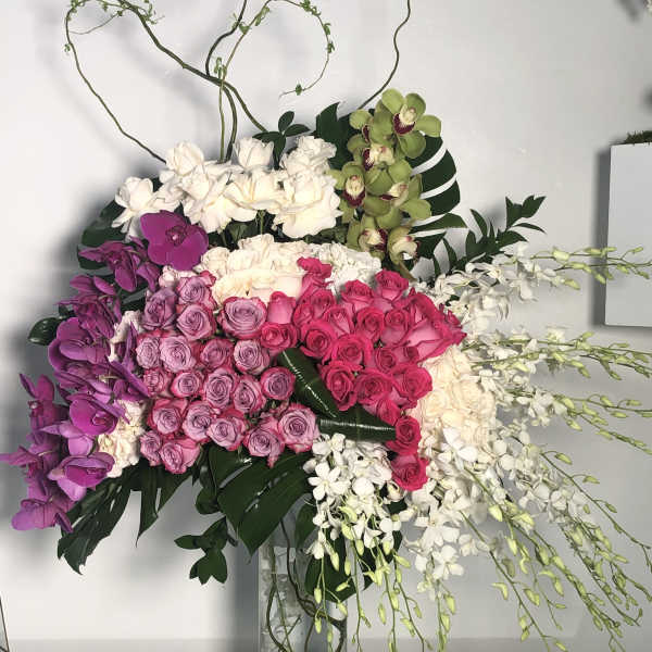 Large bouquet of pink, purple, and white flowers in a glass vase