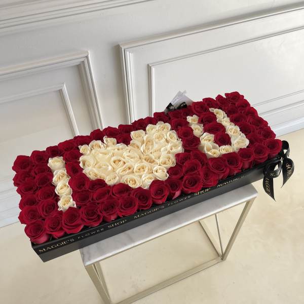 Heart-shaped box of red and cream roses on a table