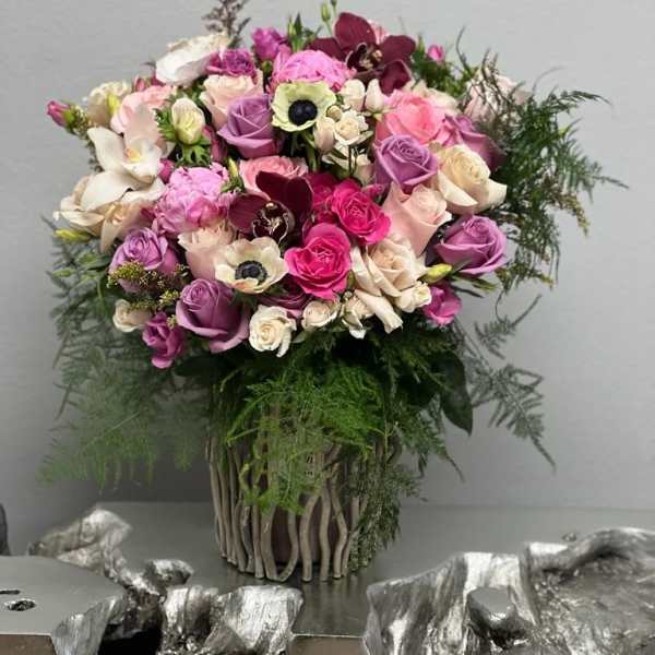 Bouquet of pink, purple, and white flowers in a woven vase