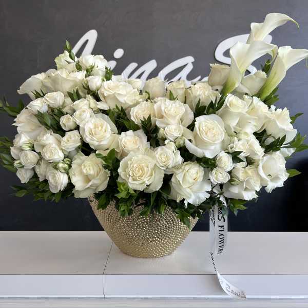 White roses and calla lilies in a gold textured vase