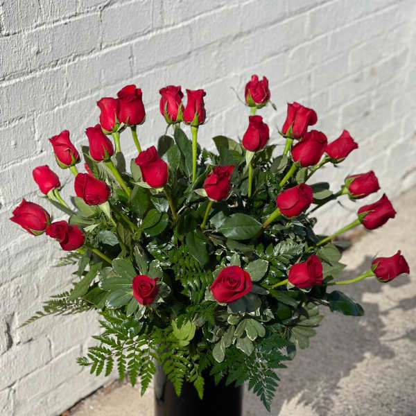 Red roses arranged in a tall black vase