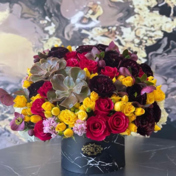 Bouquet of red, yellow, and dark purple roses in a black box