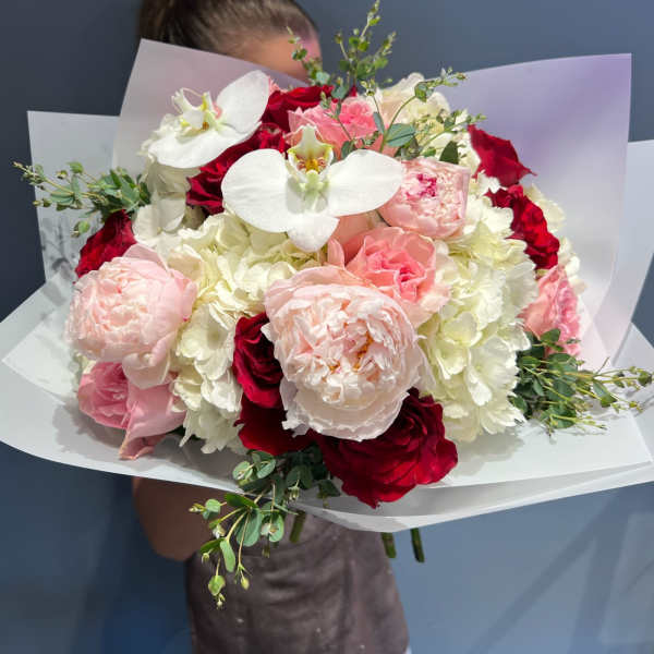 Bouquet of red, pink, and white flowers with white orchids