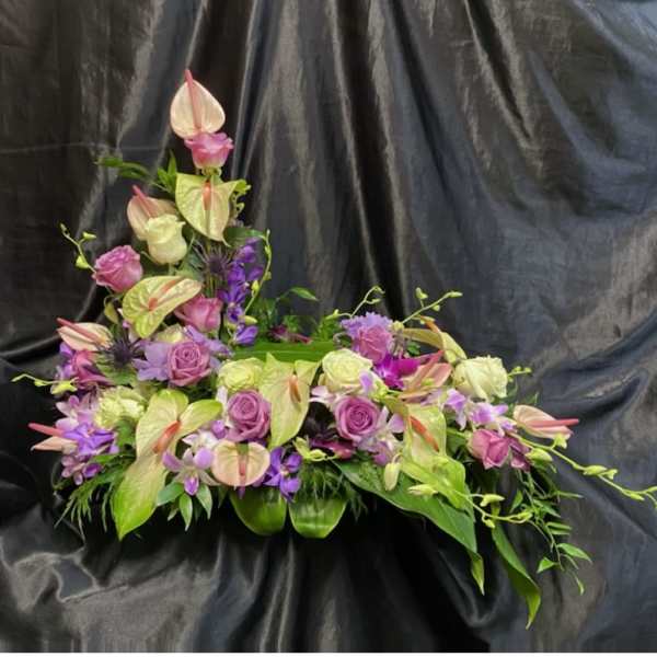 Pink and lavender floral arrangement with anthuriums and roses