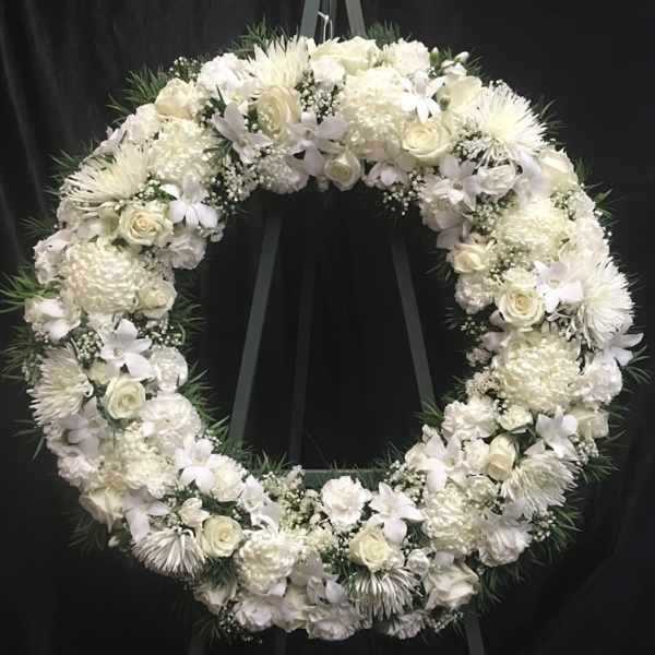 White floral wreath on a black easel
