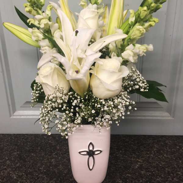 White lilies and roses in a pink vase with baby's breath