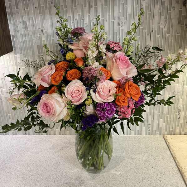 Mixed bouquet of pink and orange roses in a glass vase