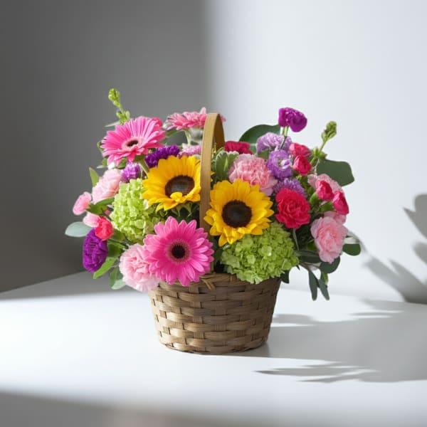Basket of mixed flowers with sunflowers, pink gerberas, and carnations