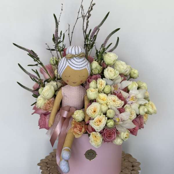 Bouquet with a fabric doll and pink and cream flowers in a pink box
