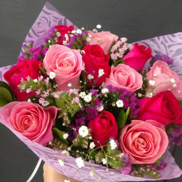 Bouquet of pink and red roses with purple filler flowers