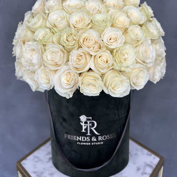 Cream-white roses arranged in a black hatbox