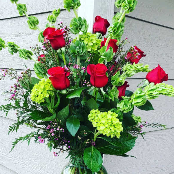 Bouquet of red roses and green hydrangeas in a glass vase