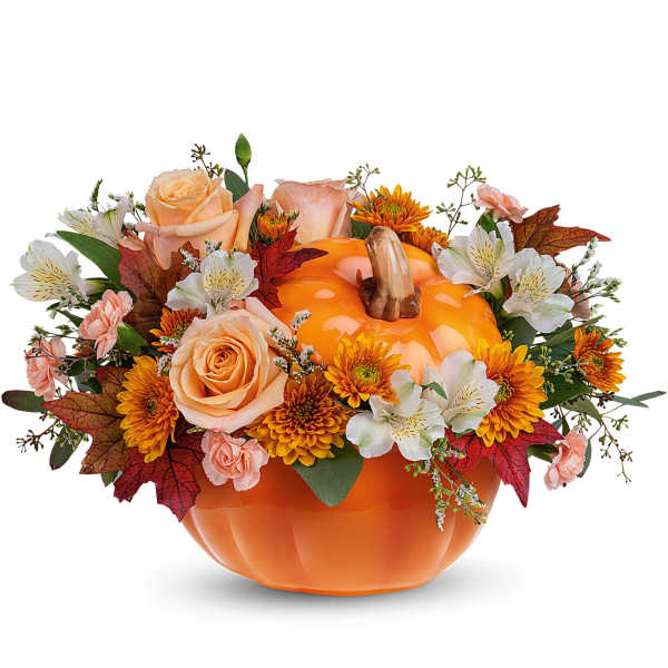 Pumpkin-shaped container filled with peach and orange flowers