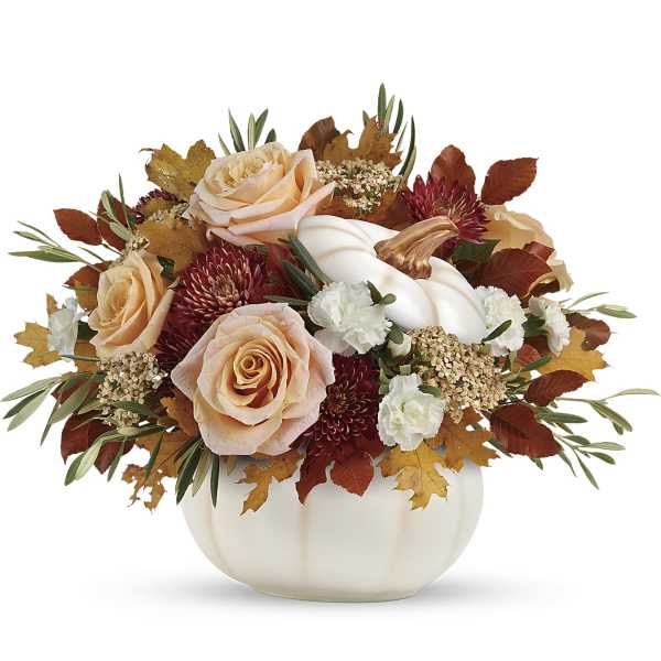 Autumn floral arrangement with peach roses in a white pumpkin vase