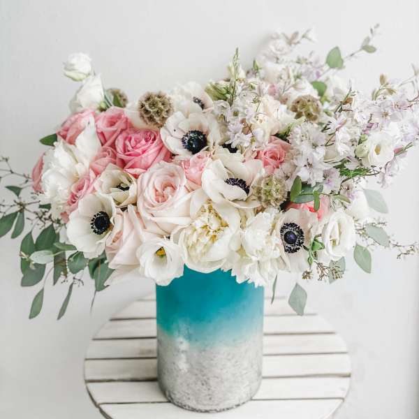 Pink and white flowers arranged in a blue vase