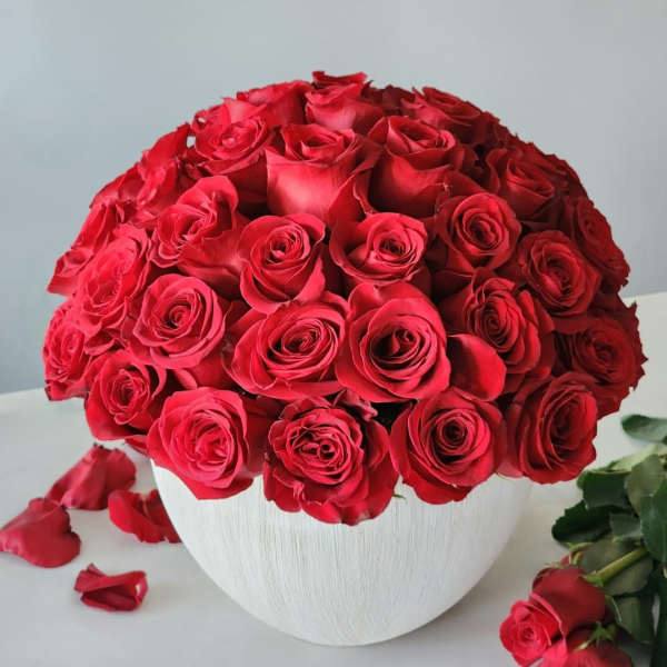 Round bouquet of red roses in a white vase