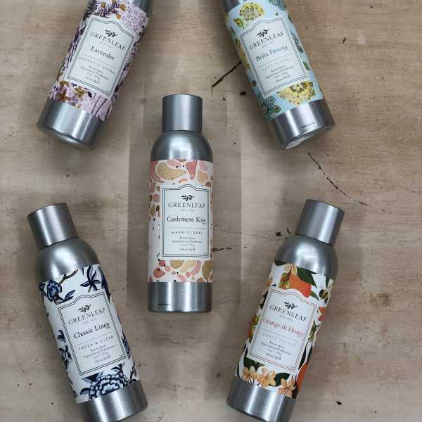 Set of five Greenleaf scented room spray bottles arranged on a wood surface