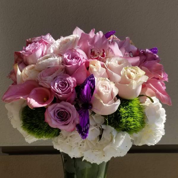Pink and white rose bouquet in a tall glass vase