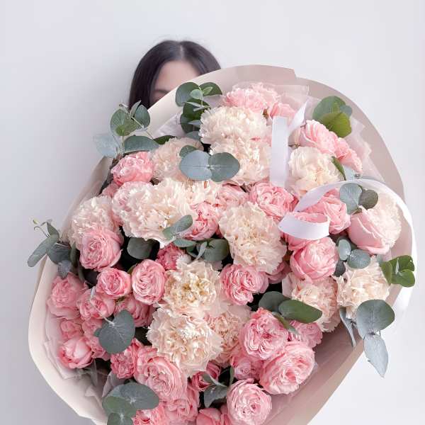 Large bouquet of pink roses and pale carnations with eucalyptus
