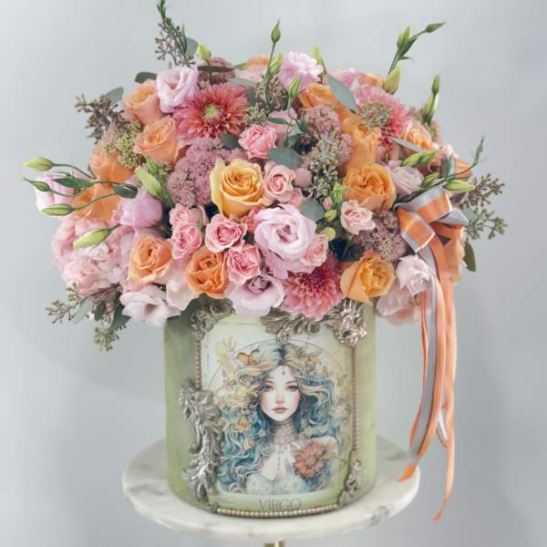 Mixed pink and peach bouquet in a decorated green box with ribbon