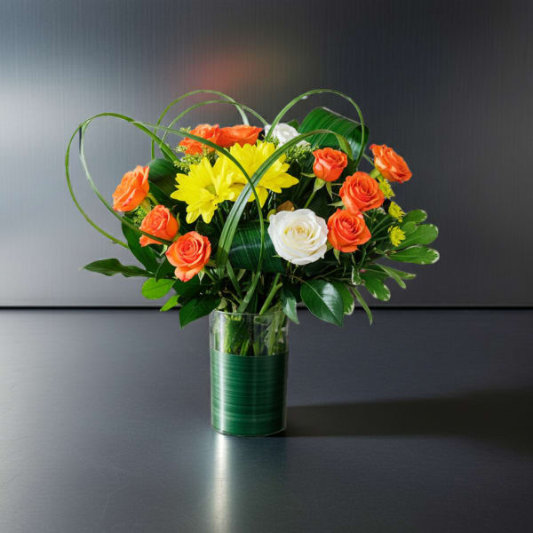 Orange and white roses with yellow daisies in a glass vase