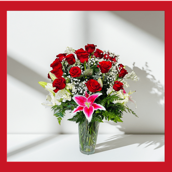 Red roses and pink lilies in a clear glass vase