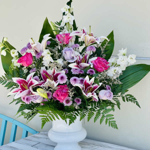 Large mixed bouquet in a white pedestal vase with pink and white flowers