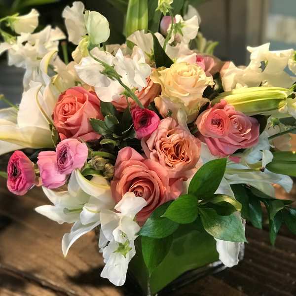 Bouquet of pink and peach roses with white lilies and orchids