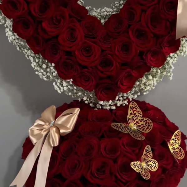 Heart-shaped red rose arrangement with baby’s breath and satin bows