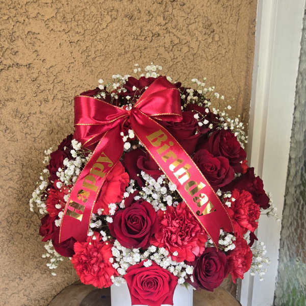 Red rose bouquet in a white box with a birthday ribbon