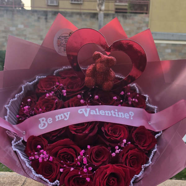 Bouquet of red roses with a pink "Be my Valentine?" ribbon and heart topper