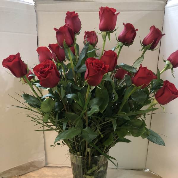 Red roses arranged in a clear glass vase