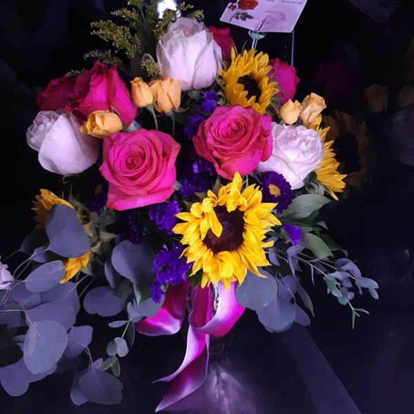 Bouquet of pink and white roses with sunflowers and purple accents
