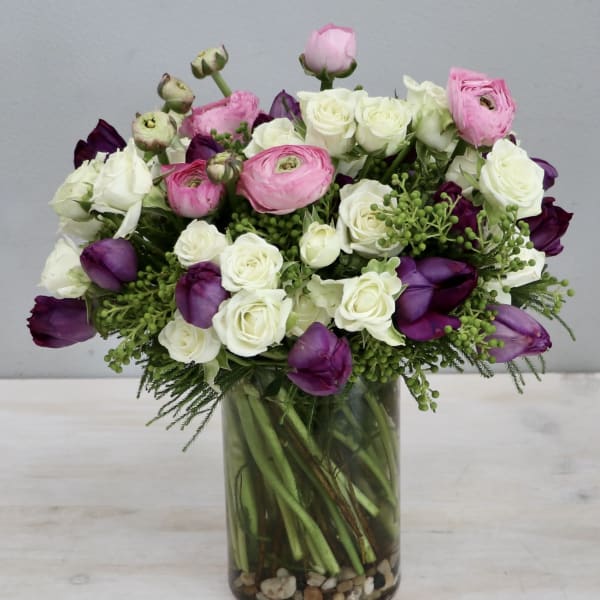 Bouquet of pink, white, and purple flowers in a glass vase